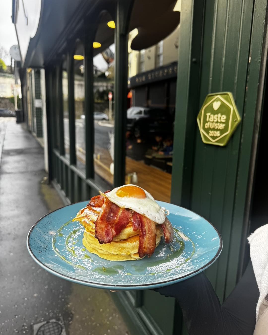 Pancakes with bacon and fried egg outside City Sips